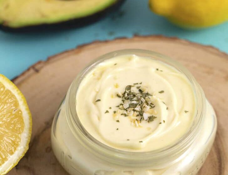 Mayonesa casera con aceite de aguacate refinado Avocado Real, limón y aguacate fresco sobre fondo azul