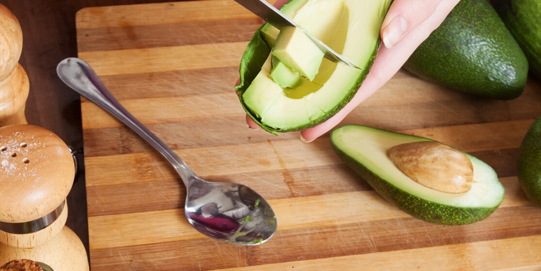 Mujer preparando aguacates frescos en cocina — imagen real food saludable