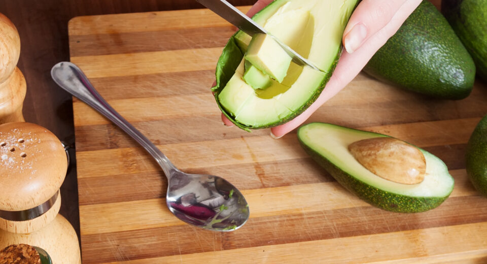 Mujer preparando aguacates frescos en cocina — imagen real food saludable