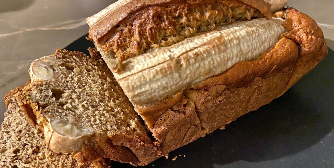 Pan de plátano casero con aceite de aguacate prensado en frío Avocado Real, sobre fondo de cocina