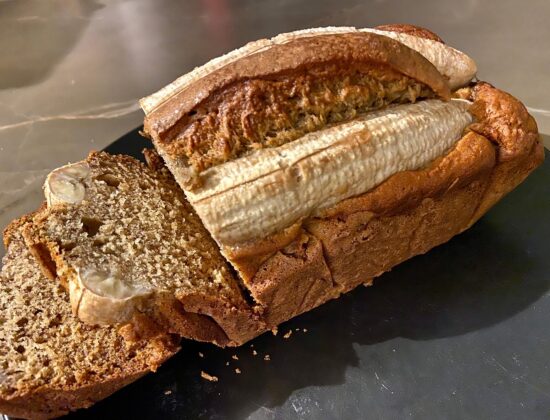 Pan de plátano casero con aceite de aguacate prensado en frío Avocado Real, sobre fondo de cocina
